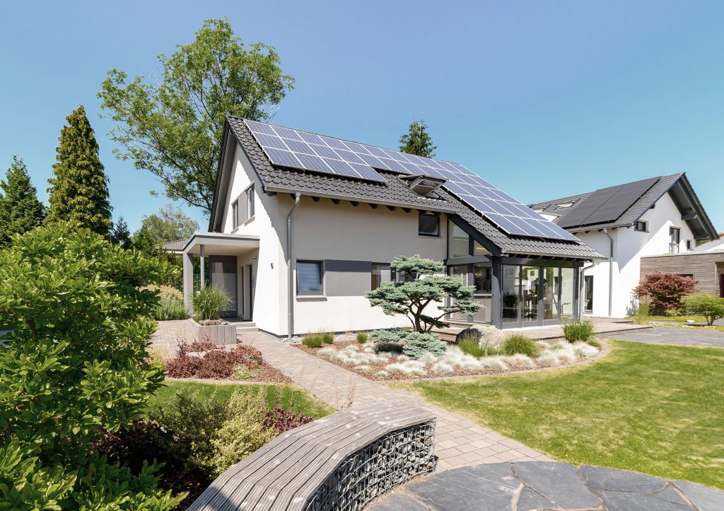 Ein modernes Einfamilienhaus mit Solarmodulen und Wintergarten